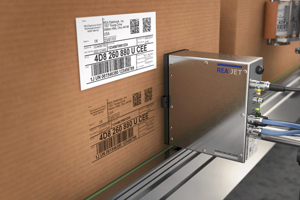 Eine materialsparende und umweltschonende Alternative: Das Direktdrucksystem REA JET UP schreibt Etiketteninhalte auf Versandkartons – auch auf glatte Oberflächen.